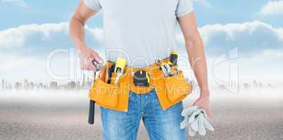 Composite image of technician holding gloves and hammer