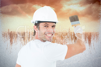 Composite image of portrait of happy man using paintbrush