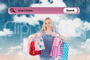 Composite image of pretty young blonde holding shopping bags