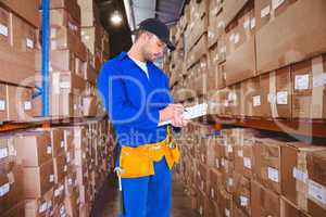 Composite image of handyman in blue overall writing on clipboard