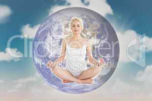 Composite image of toned young woman sitting in lotus pose with