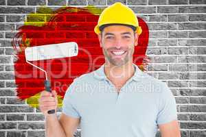 Composite image of portrait of manual worker holding paint roller