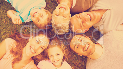 Extended family lying in circle at park