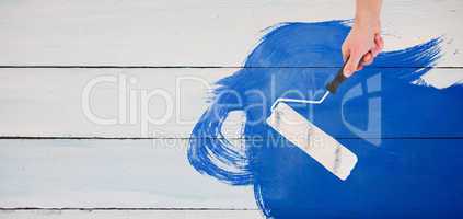 Composite image of handyman holding paint roller