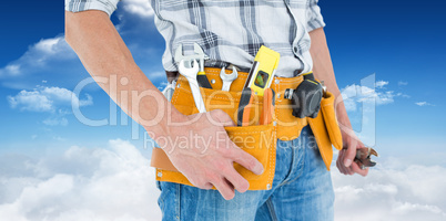 Composite image of cropped image of technician with tool belt ar