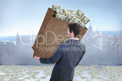 Composite image of businessman carrying bag of dollars