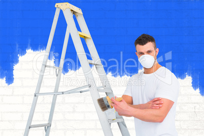 Composite image of handyman with paintbrush and ladder