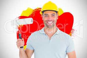 Composite image of portrait of manual worker holding paint rolle