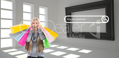 Composite image of blonde in winter clothes holding shopping bag