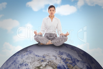 Composite image of businesswoman sitting in lotus pose