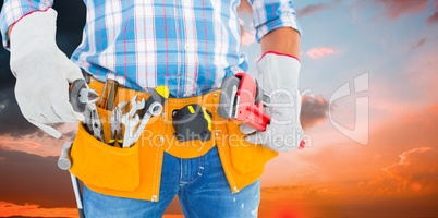 Composite image of midsection of handyman holding hand tools