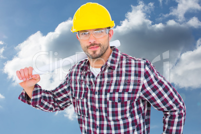 Composite image of handyman holding rolled up blueprint