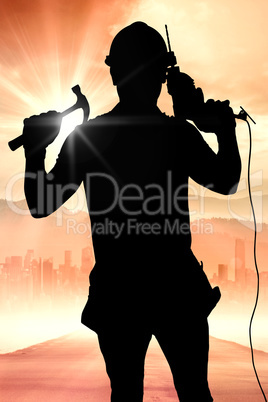 Composite image of smiling handyman holding hammer and drill mac