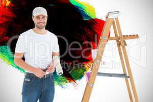 Composite image of man holding paint roller while standing by la