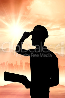 Composite image of manual worker wearing hardhat while holding c