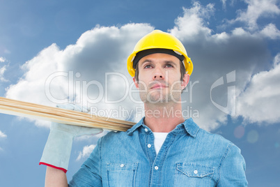 Composite image of worker carrying wooden planks