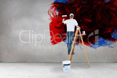 Composite image of man on ladder painting with roller