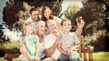 Family sitting on a bench taking photo of themselves