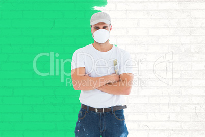 Composite image of man with paintbrush standing arms crossed by
