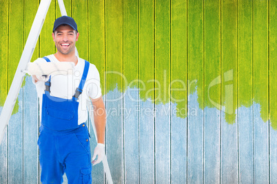 Composite image of handyman using paint roller on white backgrou