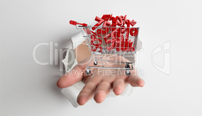 Composite image of hand bursting through paper