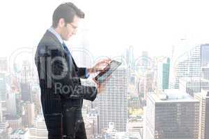 Composite image of businessman standing while using a tablet pc