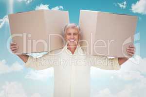 Composite image of happy man holding boxes