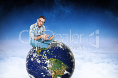 Composite image of handsome hipster using tablet pc