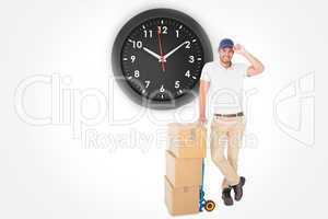Composite image of happy delivery man leaning on trolley of boxe