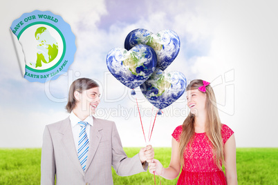 Composite image of smiling geeky couple holding red balloons