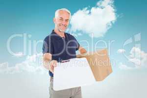 Composite image of happy delivery man holding cardboard box and