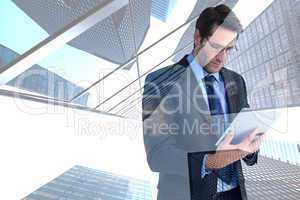Composite image of businessman using a tablet computer