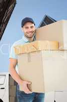 Composite image of happy delivery man carrying cardboard boxes