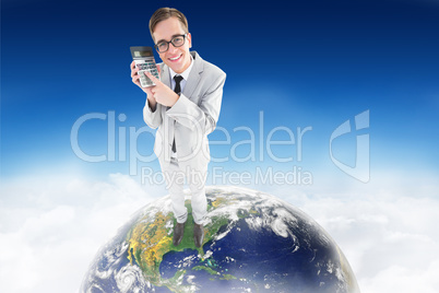 Composite image of geeky smiling businessman showing calculator