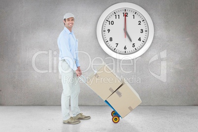 Composite image of confident delivery man pushing trolley of car