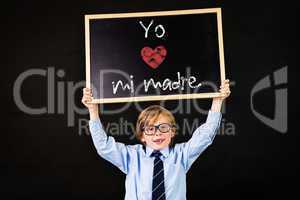 Composite image of cute pupil holding chalkboard