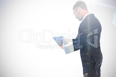 Composite image of businessman using his tablet pc