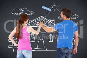 Composite image of couple painting a wall together