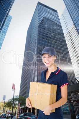 Composite image of happy delivery woman holding cardboard box