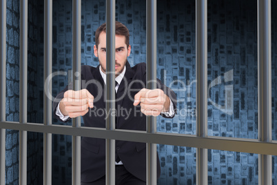 Composite image of angry businessman standing with clenched fist
