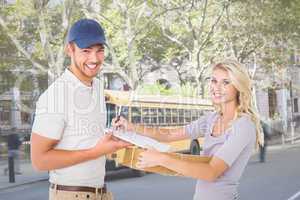 Composite image of happy delivery man giving package to customer