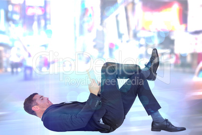 Composite image of businessman lying on the floor reading book