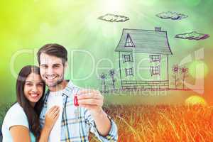 Composite image of happy young couple holding new house key