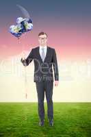 Composite image of happy geeky hipster businessman holding ballo