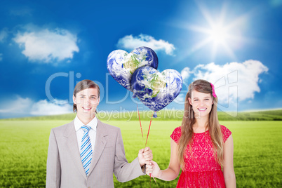 Composite image of smiling geeky couple holding red balloons