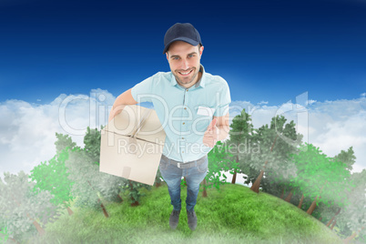Composite image of delivery man with cardboard box gesturing thu