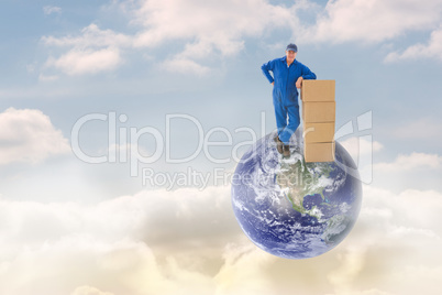 Composite image of happy delivery man leaning on pile of cardboa