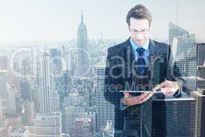 Composite image of businessman standing while using a tablet pc