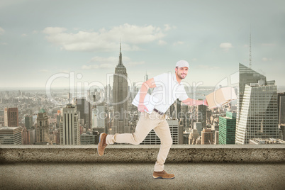 Composite image of delivery man with cardboard boxes running