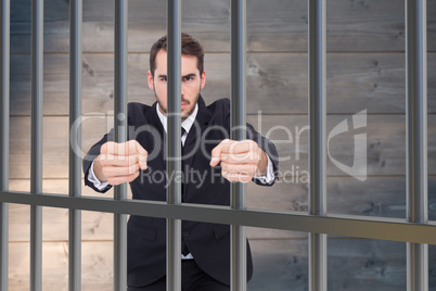 Composite image of angry businessman standing with clenched fist